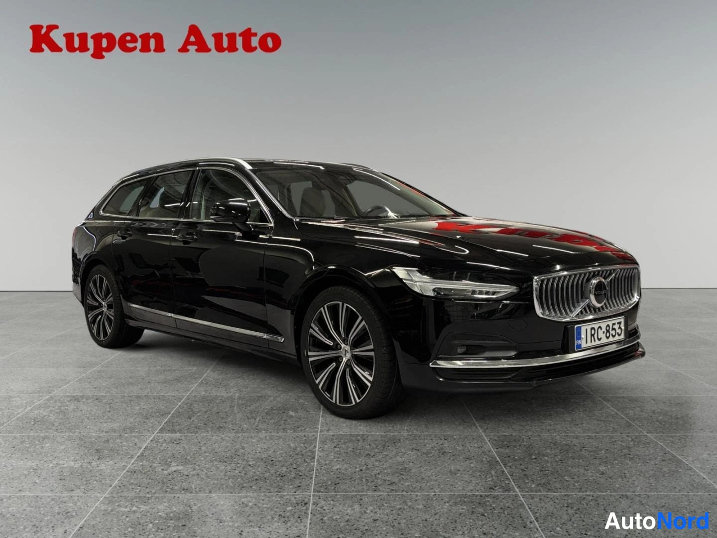 Etuviisto, nokka oikealle: Musta Volvo V90 -asema-auto etuviistosta oikealta, rekisterikilpi.