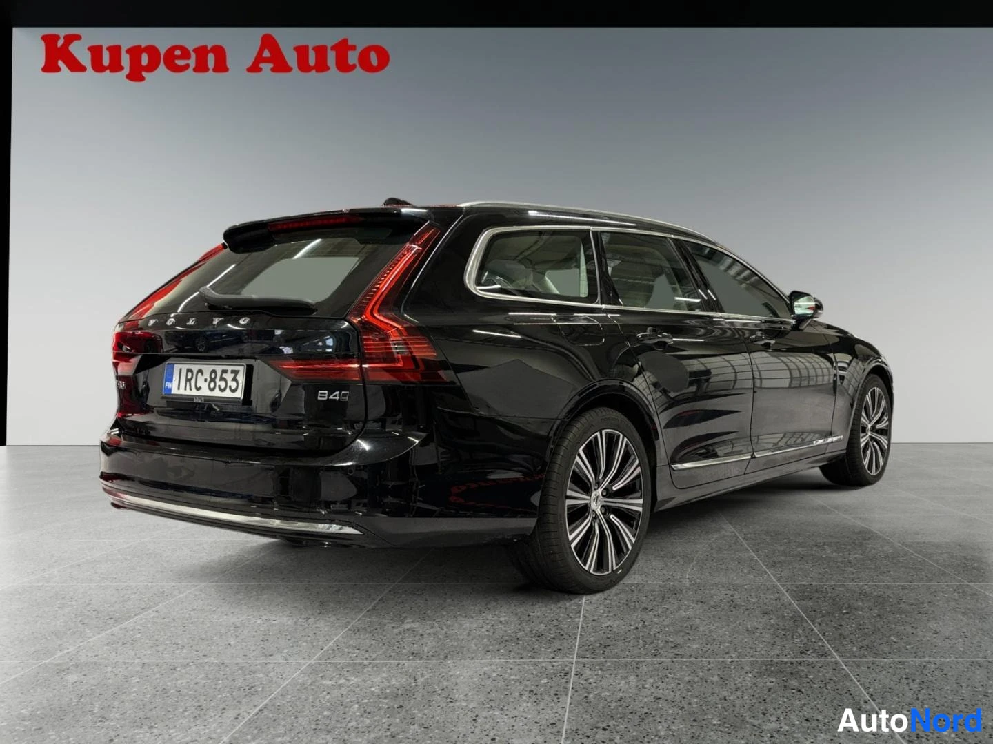 Takaviisto: Musta Volvo V90 -asema-auto takaviistosta vasemmalta, VOLVO-teksti ja B4-merkintä takaluukussa.