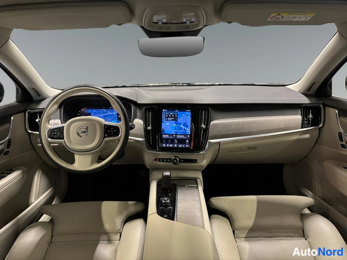 Muu: Volvo V90:n ohjaamo etupäin: beige nahkaverhoillut etuistuimet, kokolujuus säädettävä ohjauspyörä ja suuri pystykosketusnäyttö, jossa kartta. Katto ja kojelauta
