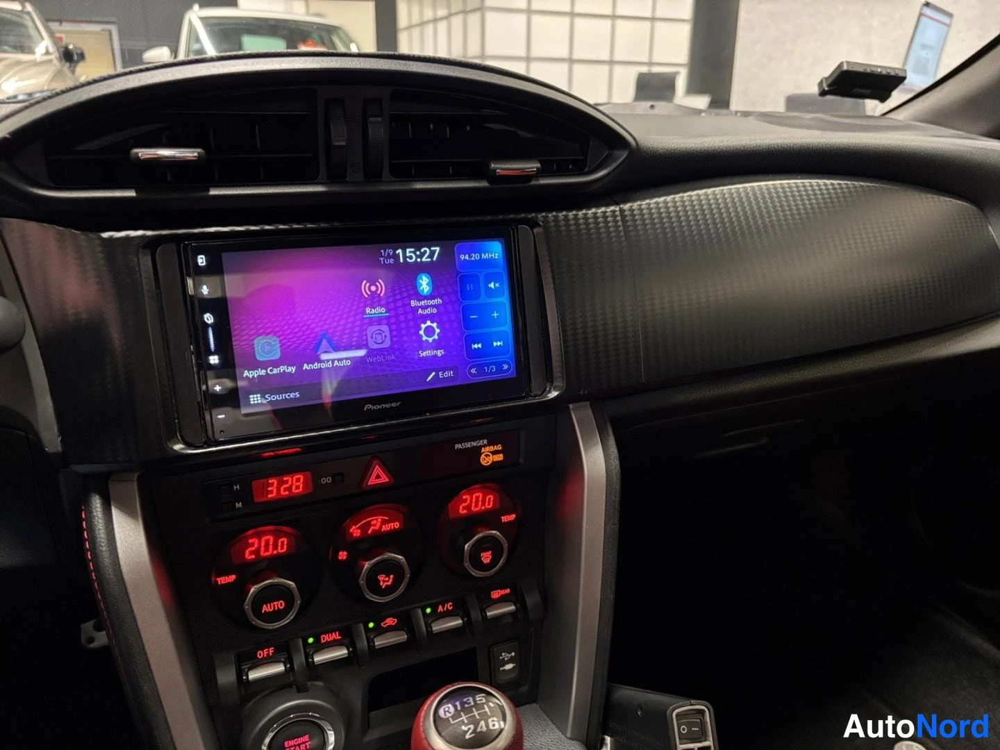 Muu: Kojelaudan keskiosa: Pioneer-kosketusnäyttö valikossa (Apple CarPlay, Android Auto, Radio, Bluetooth Audio), Passenger Airbag -merkintä ja digitaaliset ilmastoi