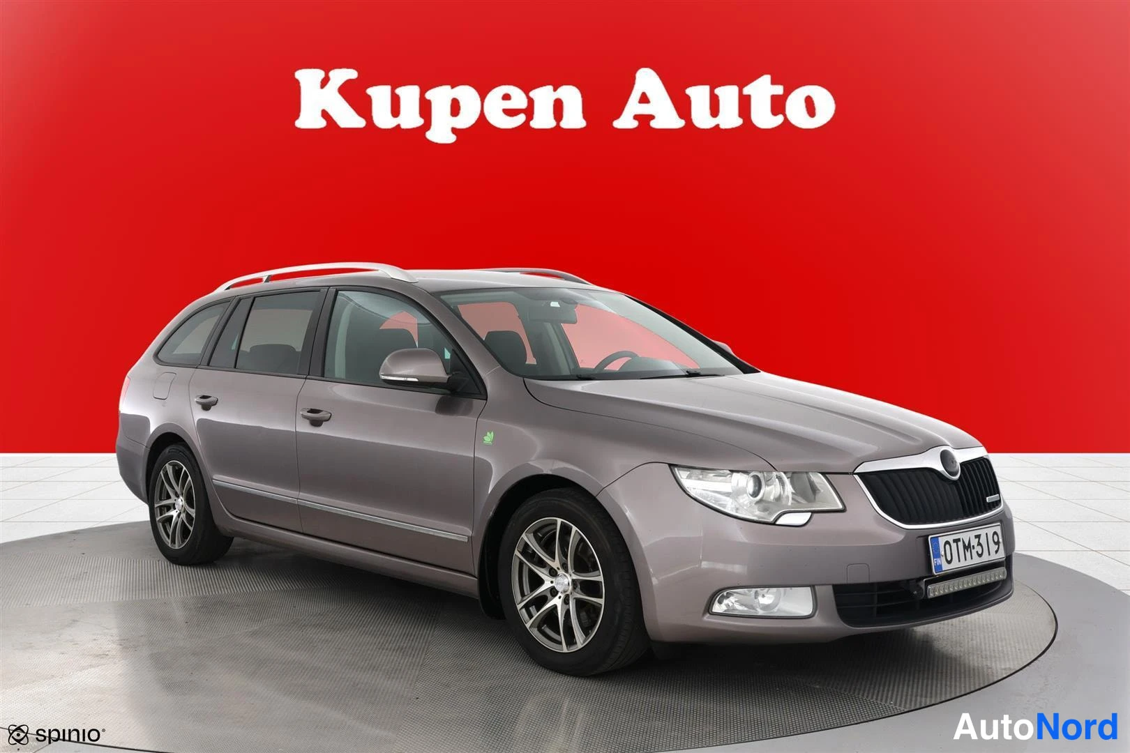 Etuviisto, nokka oikealle: Farmarikorinen auto kulmassa kuvattuna, keulapuoli ja vasen kylki näkyvät; vaalean beige/kultaansävyinen kori, kattokaiteet ja hopeavanteet.