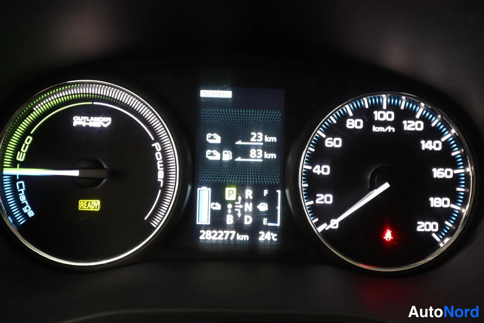 Yksityiskohta: Mittaristo, jossa polttoainemittari ja nopeusmittari, näytöllä 282277 km ja 24 °C, p-polkim valittu.