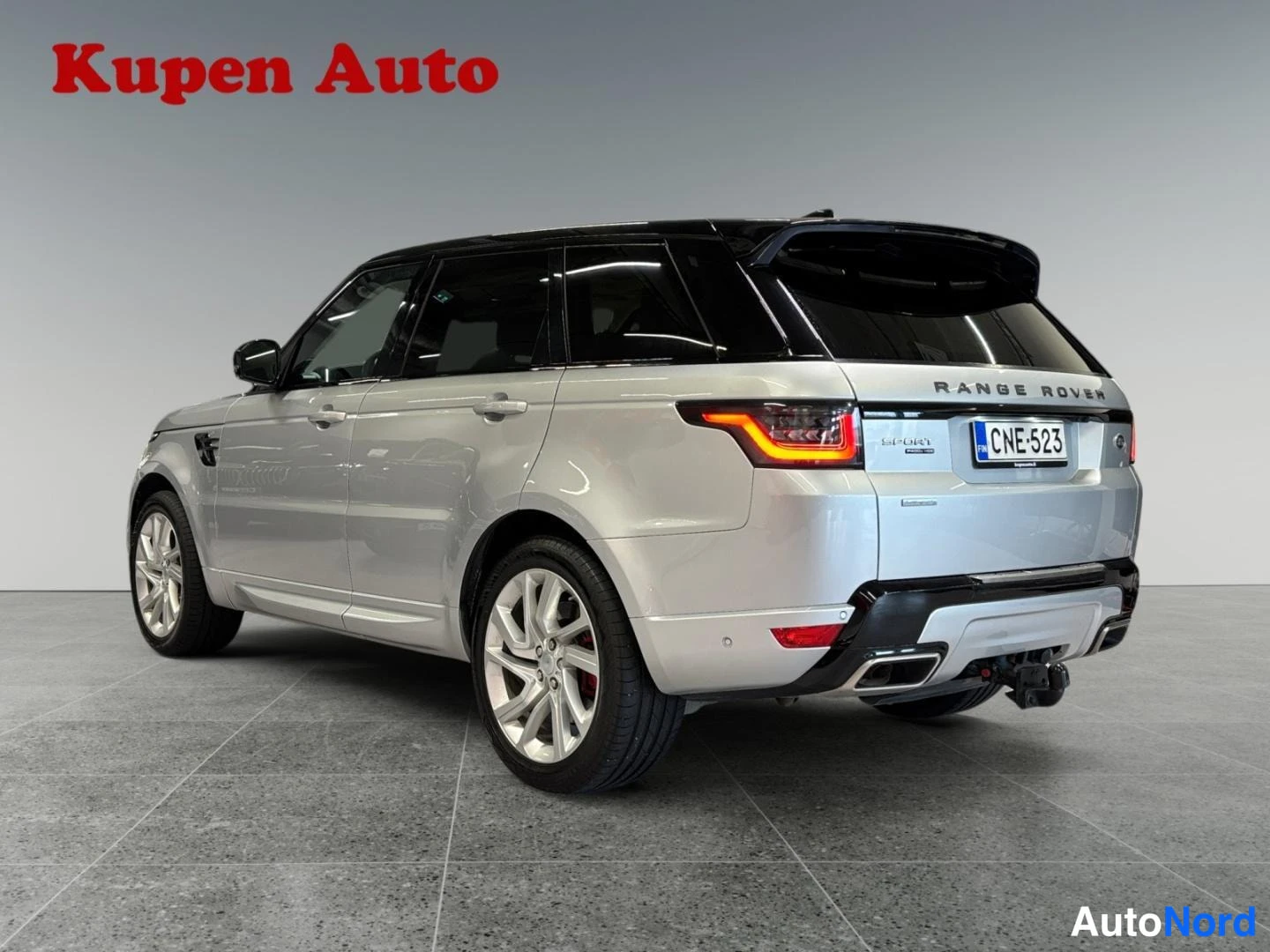 Takaviisto: Hopeanvärinen Range Rover Sport takakulmasta, rekisterikilpi, musta katto jatakavalo.