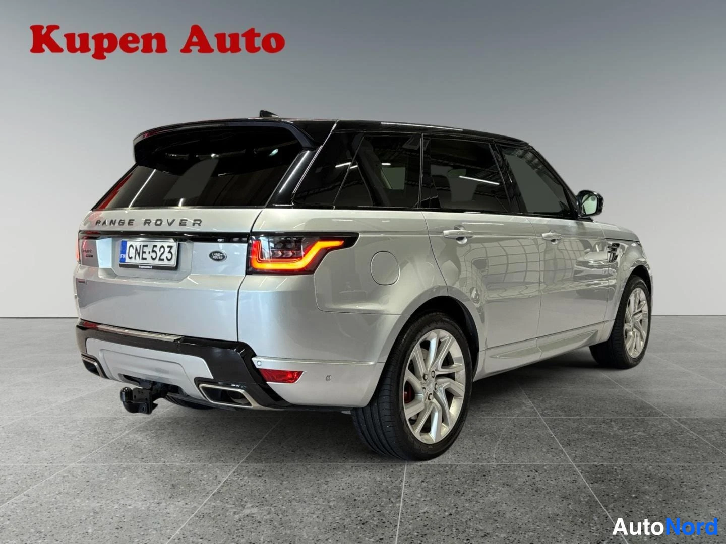 Takaviisto: Hopeanvärinen Range Rover Sport takakulmasta vasemmalta, rekisterikilpi, musta katto ja punainen takavalo.