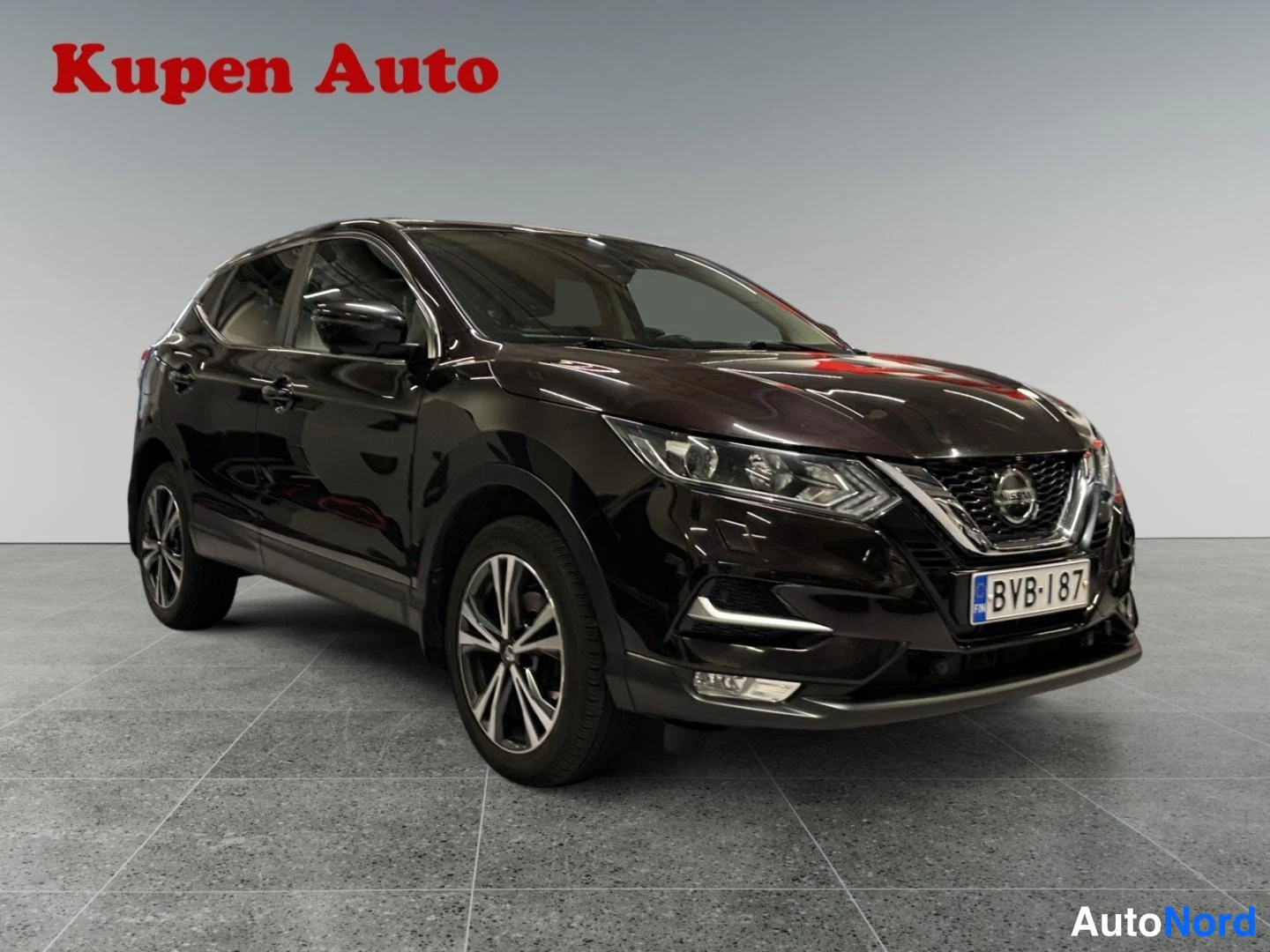 Etuviisto, nokka oikealle: Nissan Qashqai, tummanpunainen farmarikori kuvattu kolmanneltse edestä oikealta, rekisteritunnus.
