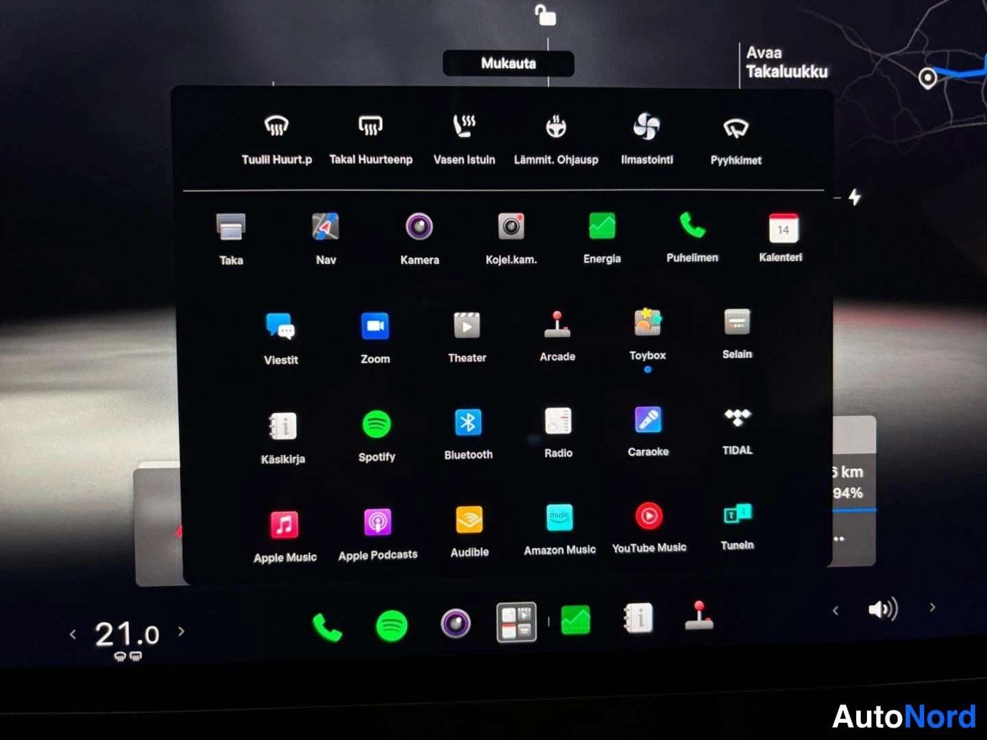 Muu: Tesla Model 3:n keskityynyt avattu sovellusvalikko kuvakkeineen kuten Navi, Kamera, Energia, Spotify, Bluetooth ja Pelit.