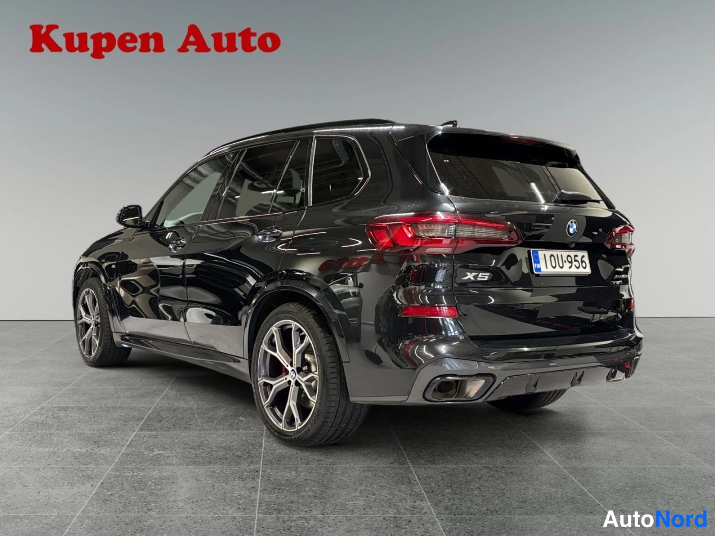 Takaviisto: Musta BMW X5:n takakulma kuvattuna vasemmalta takaa, rekisterikilpi OU-956 ja X5-merkintä.