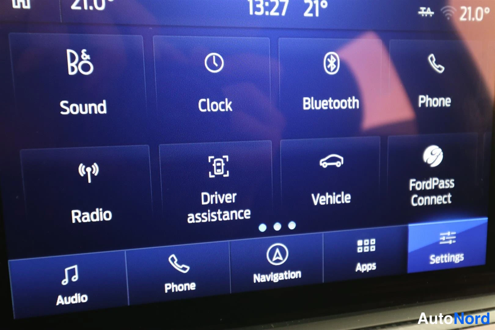 Muu: Auton kosketusnäytön asetusvalikko: kuvakkeet Sound, Clock, Bluetooth, Phone, Radio, Driver assistance, Vehicle ja FordPass Connect, alareunassa palkkirivi.