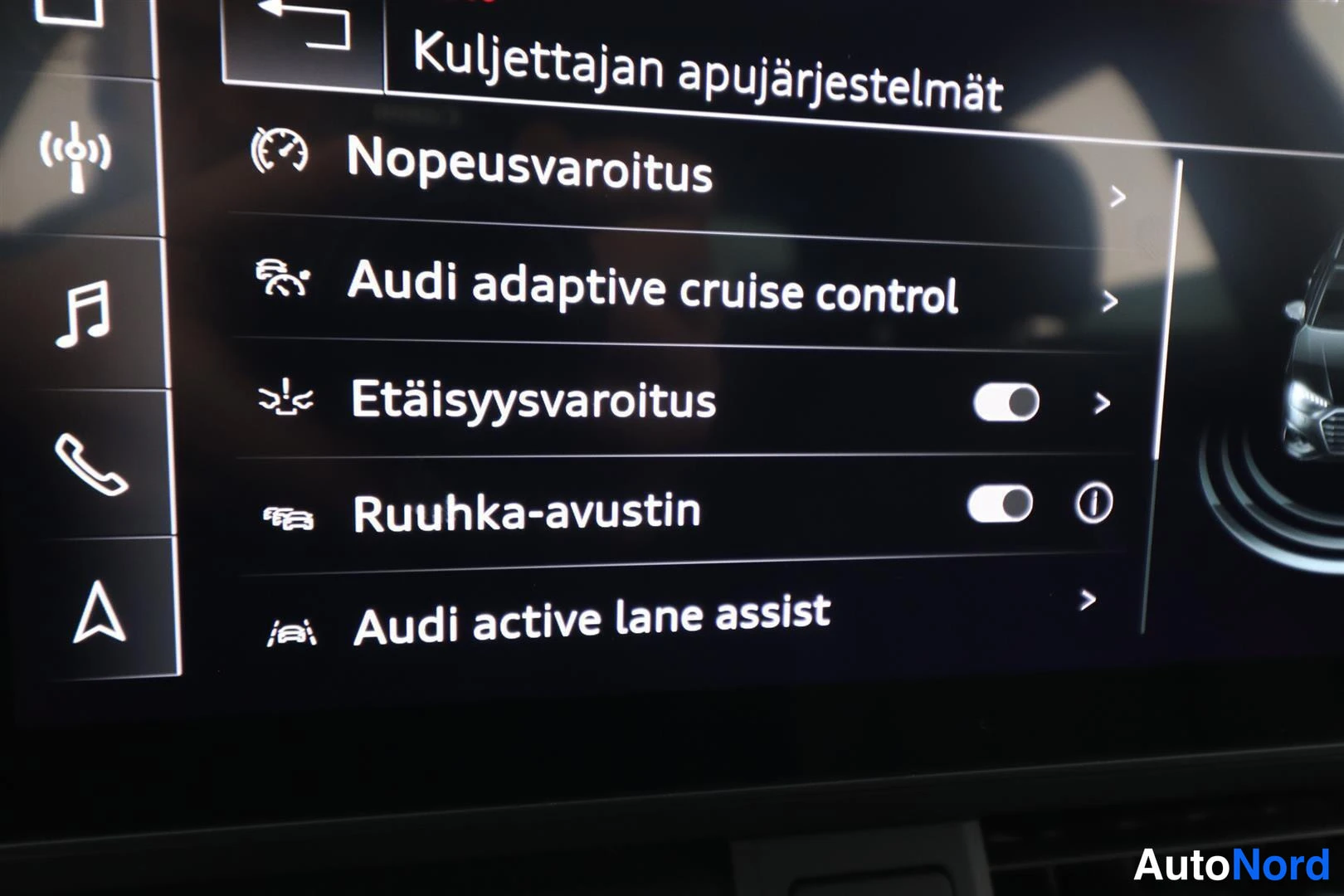 Yksityiskohta: Multimedianäyttö valikossa 'Kuljettajan aputyärjestelmät', jossa mm. Audi adaptive cruise control, Etäisyysvaroitus, Ruuhka-avustin ja Audi active lane assist.