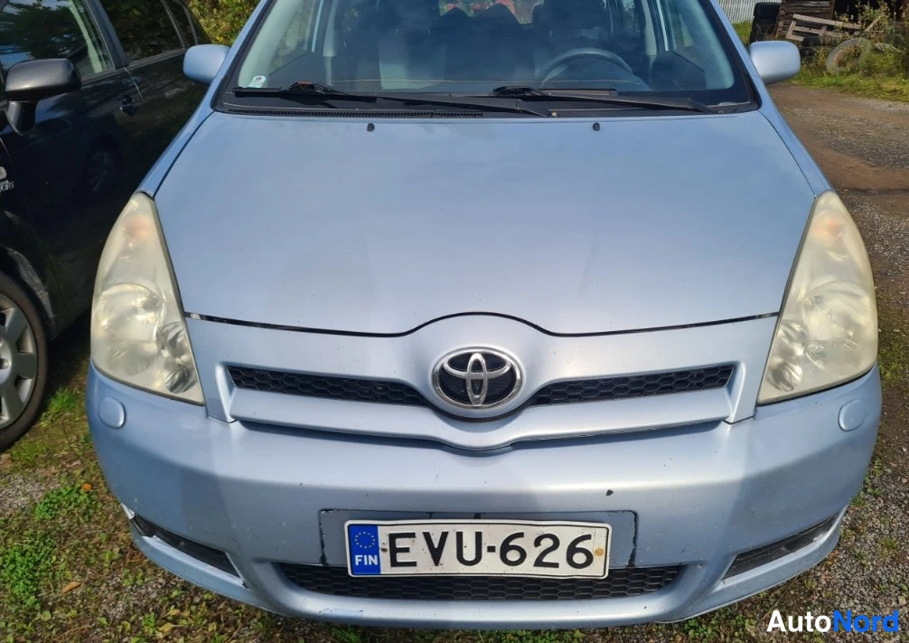 Edestä: Vaaleansinisen auton etunäkymä, keulalla Toyota-merkki, rekisterikilpi.