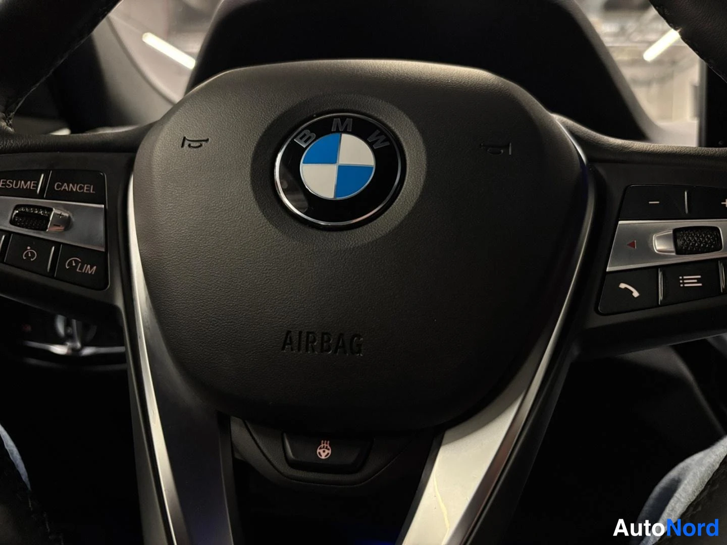 Yksityiskohta: BMW-ohjauspyörän keskusta, AIRBAG-teksti ja monitoiminapit