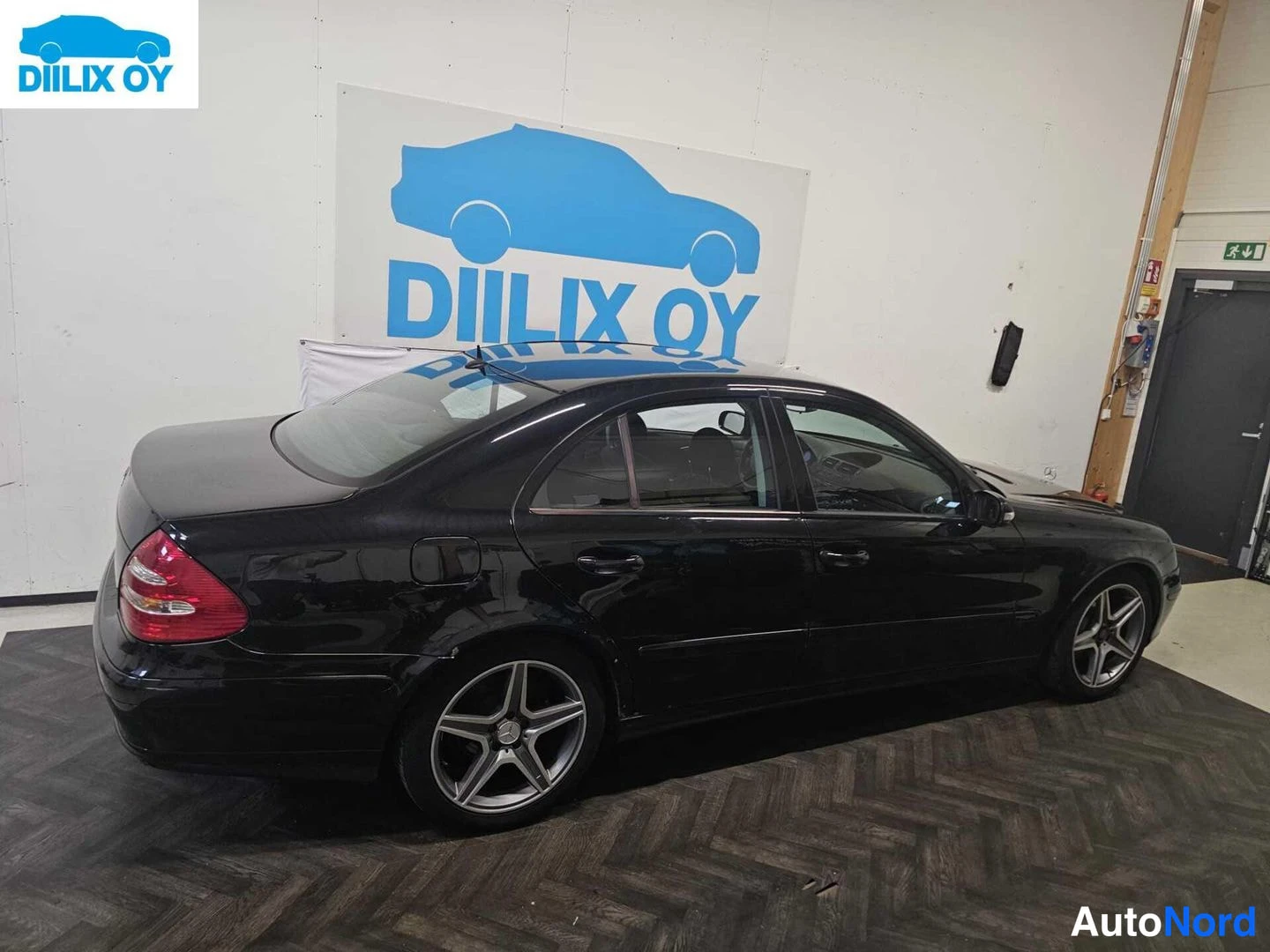 Sivulta: Side profile view of a dark sedan showing both front and rear wheels.