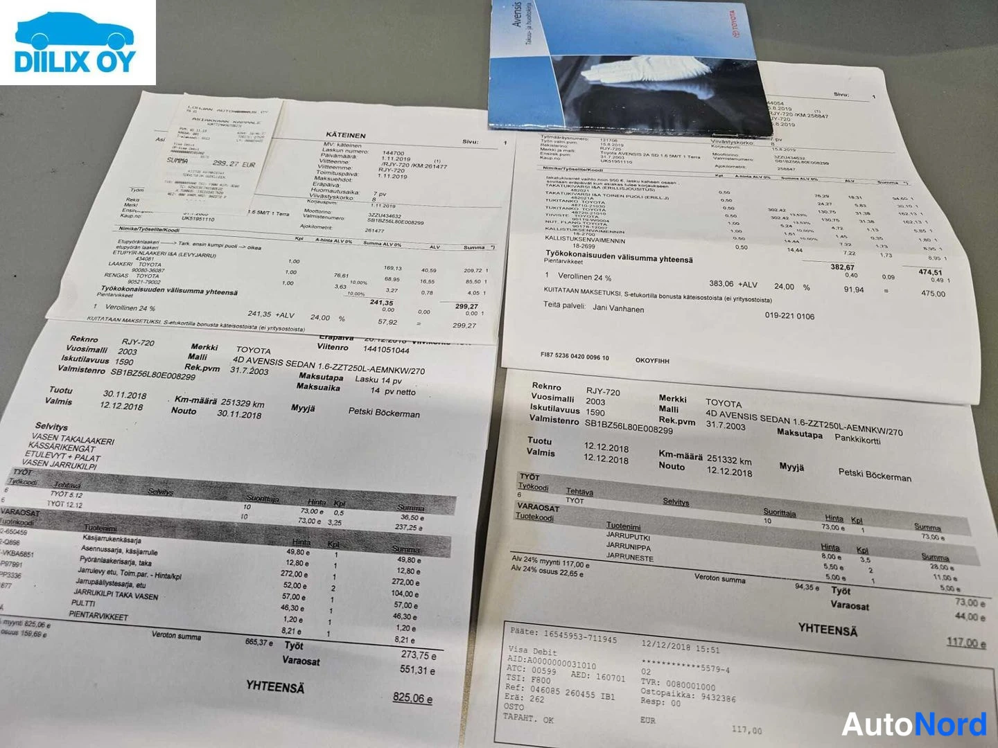 Asiakirja: Toyota Avensisin huoltolaskuja pöydällä: kaksi tulostettua kuitia, joissa työ- ja varaosakuluja, yhteensä 825,08 € ja 117,00 €, ja osin sininen Atea-kansio.