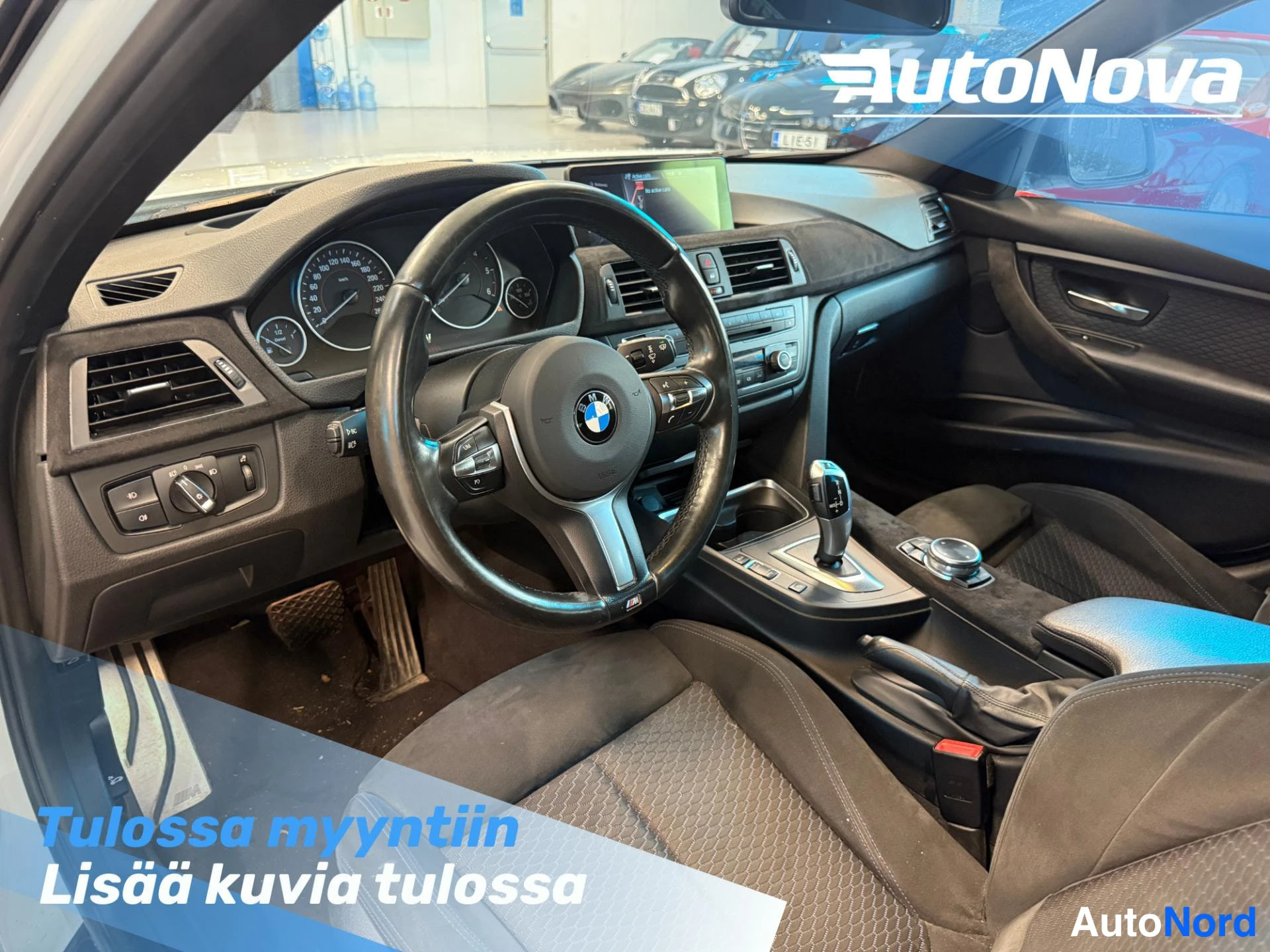 Etuviisto, nokka vasemmalle: Kuljettajan puolen sisätila: nahkainen BMW-ohjauspyörä, analogiset mittarit, kosketusnäyttö, automaattivaihteen valitsin ja tummat istuimet.