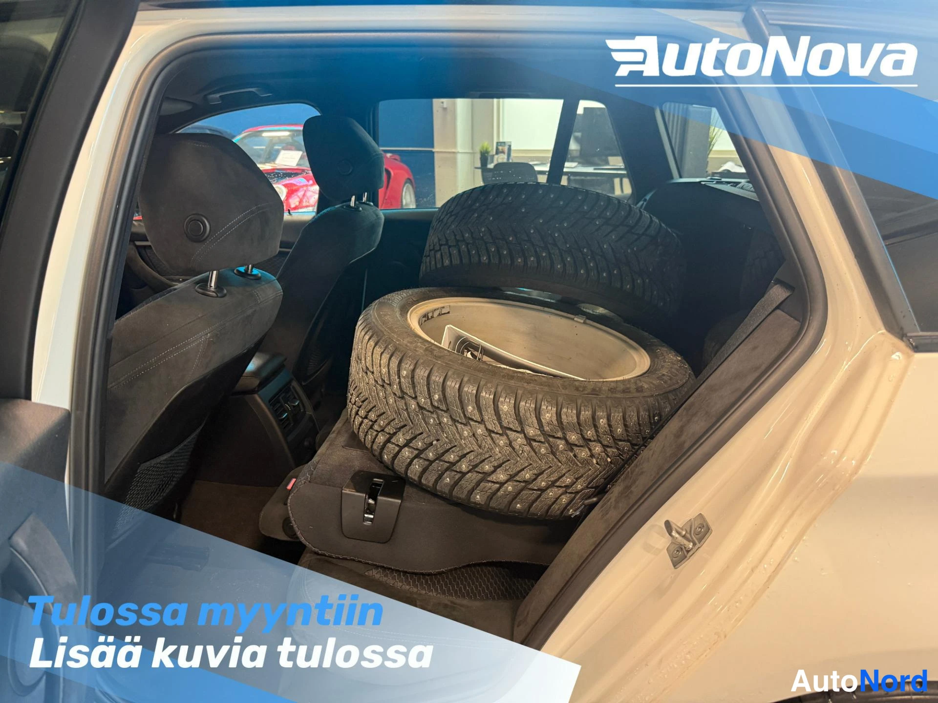 Etuviisto, nokka vasemmalle: Takaistuimet taitettuna; takakontissa kaksi nastarenkaalla varustettua talvirengasta vanteilla.
