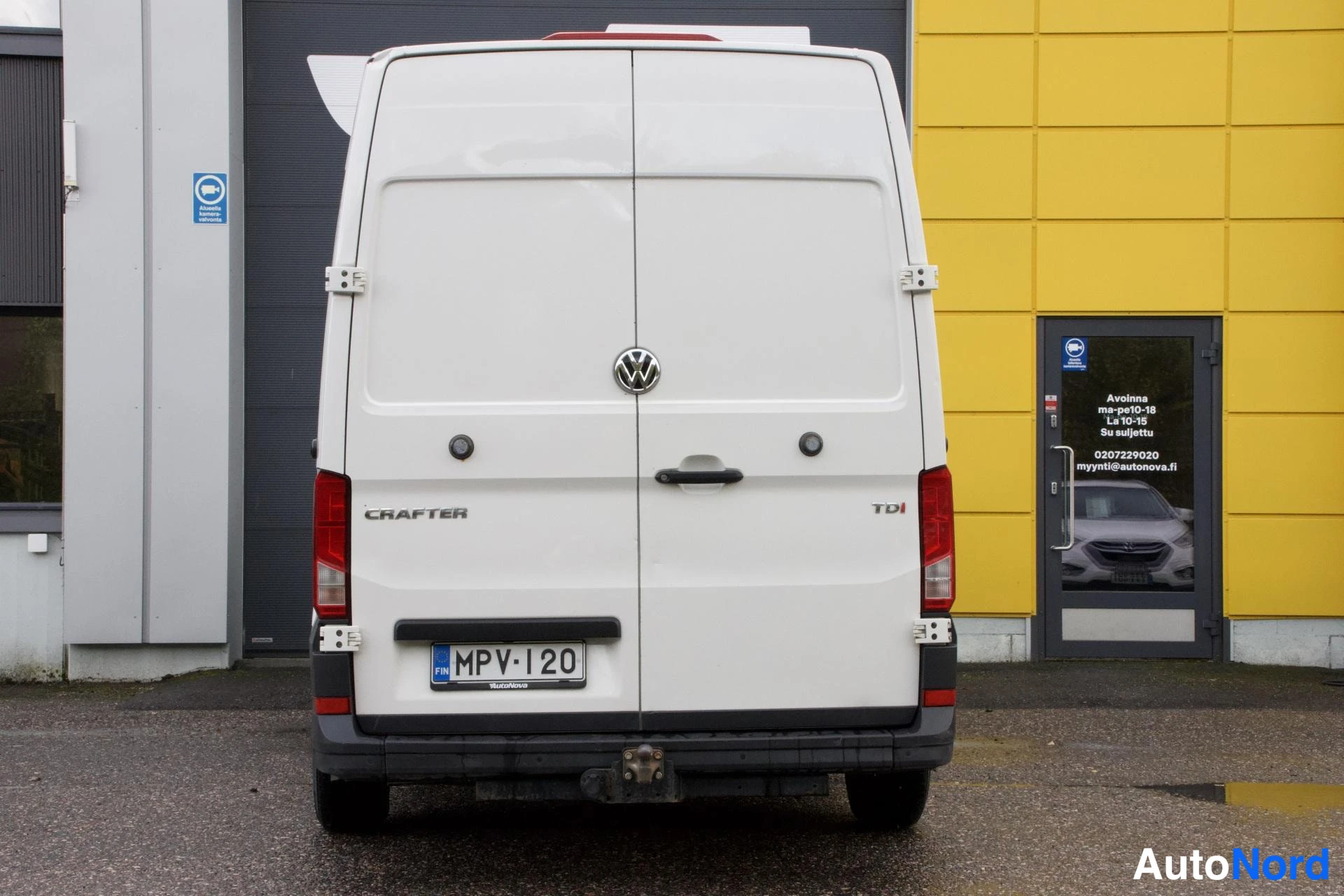 Takaa: Valkoisen Volkswagen Crafter -pakettiauton takapää; rekisterikilpi, CRAFTER- ja TDI-tekstit sekä VW-merkki peräovessa.