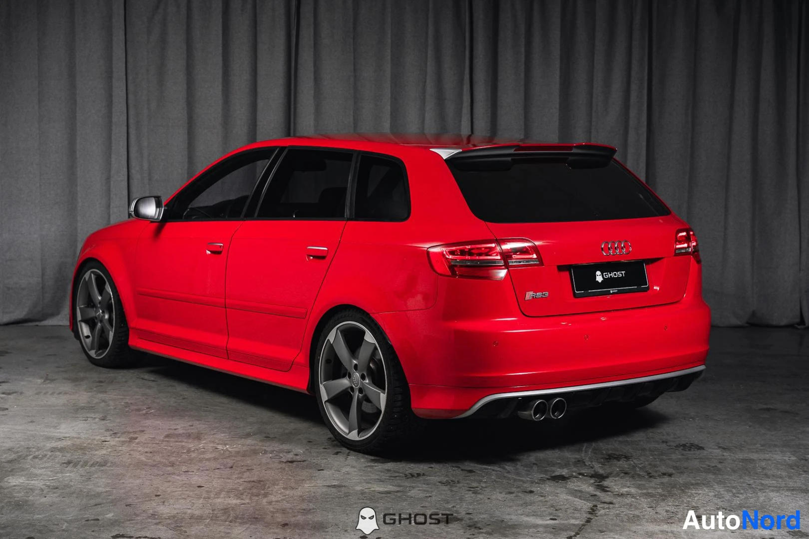 Takaviisto: Punainen Audi A3 Sportback takaviistosta vasemmalta, RS3-merkintä takaluukissa.