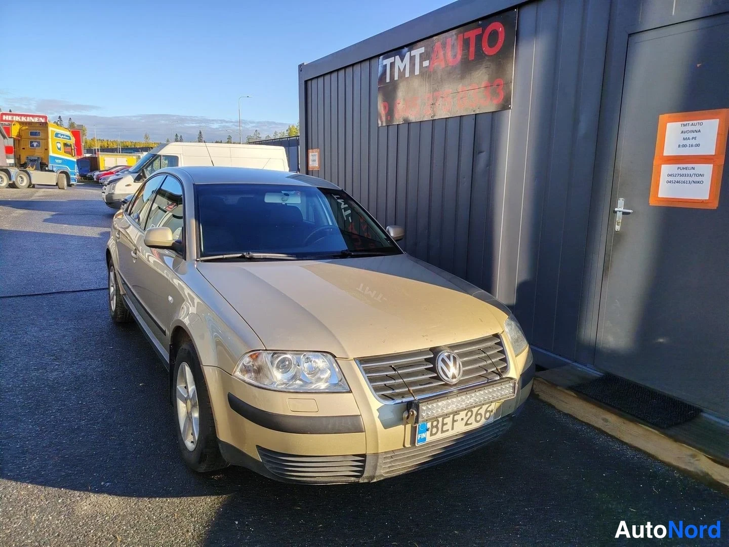 Etuviisto, nokka oikealle: Volkswagen Passat -sedanin keula oikealla kulmasta, kulta-beige runko,.