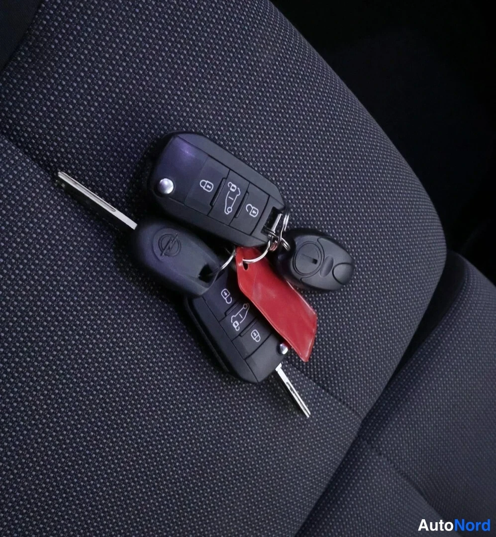 Muu: Kaksi kauko-ohjainta ja Opel-avain istuinverhouksen päällä
