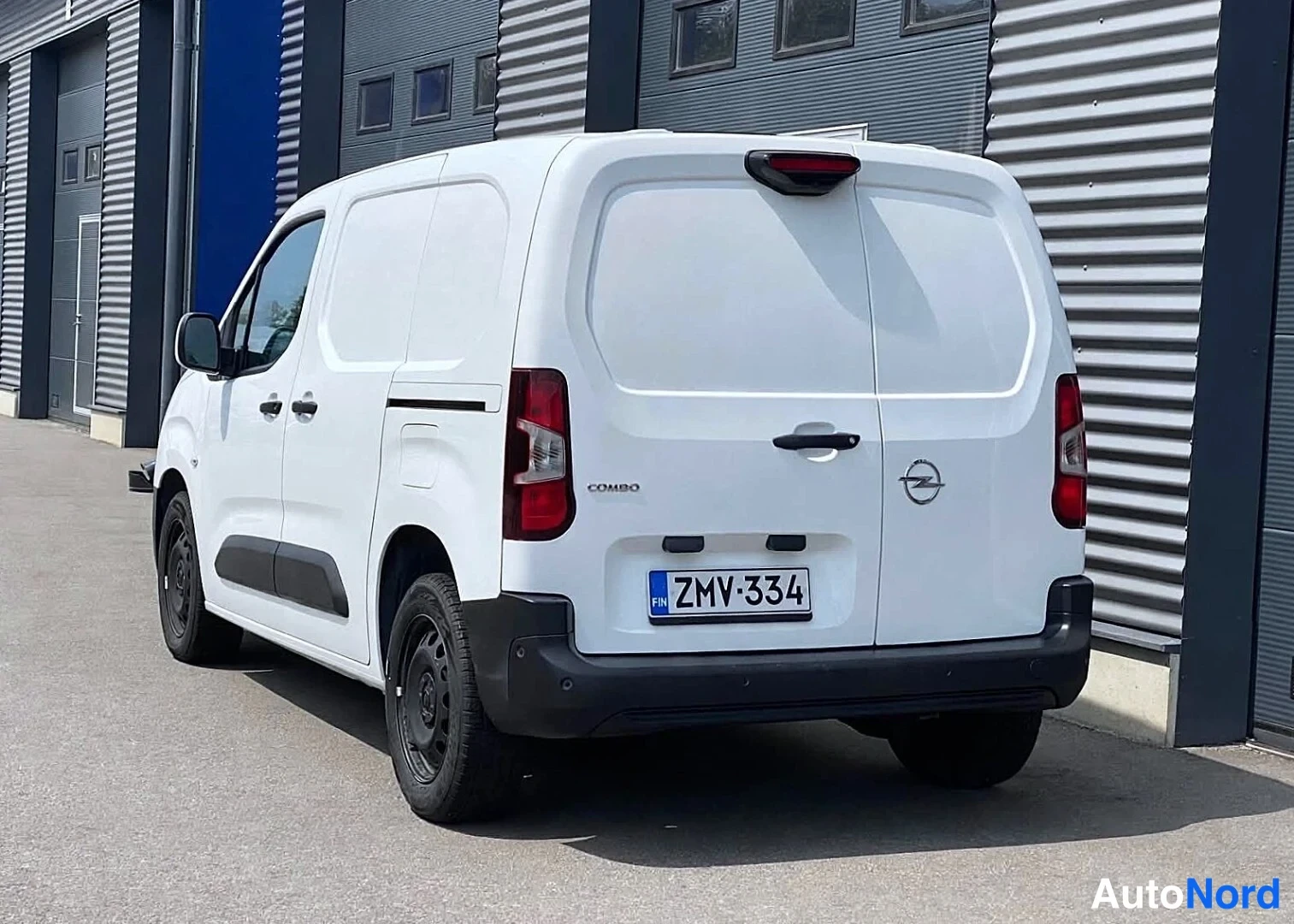 Takaviisto: Valkoinen pakettiauto takaa vasemmalta, rekisterikilpi, takaluukussa COMBO-teksti.