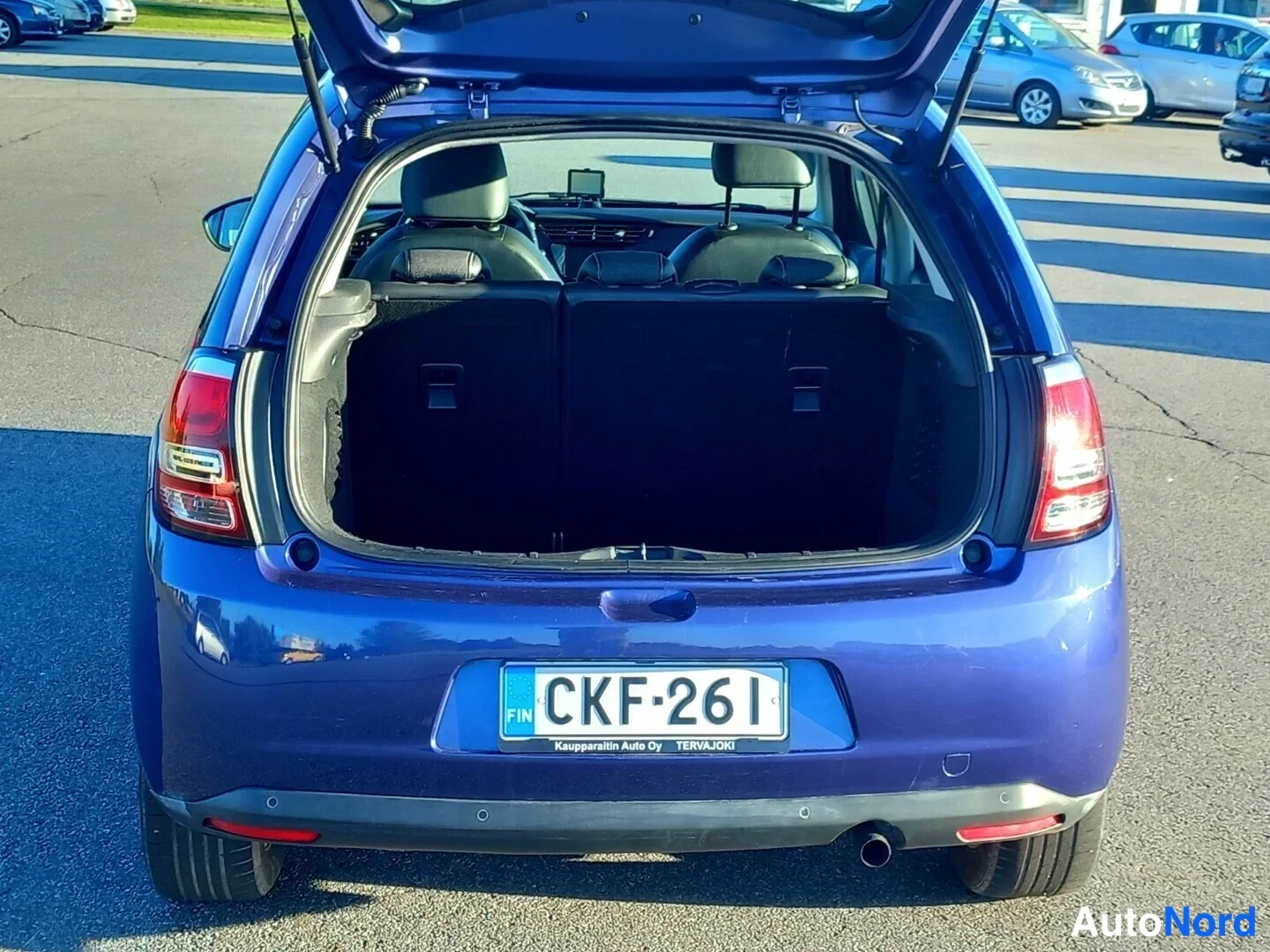 Takaa: Sinisen Citroën C3:n avattu tavaratila, takaa kuvattu; rekisterikilpi.