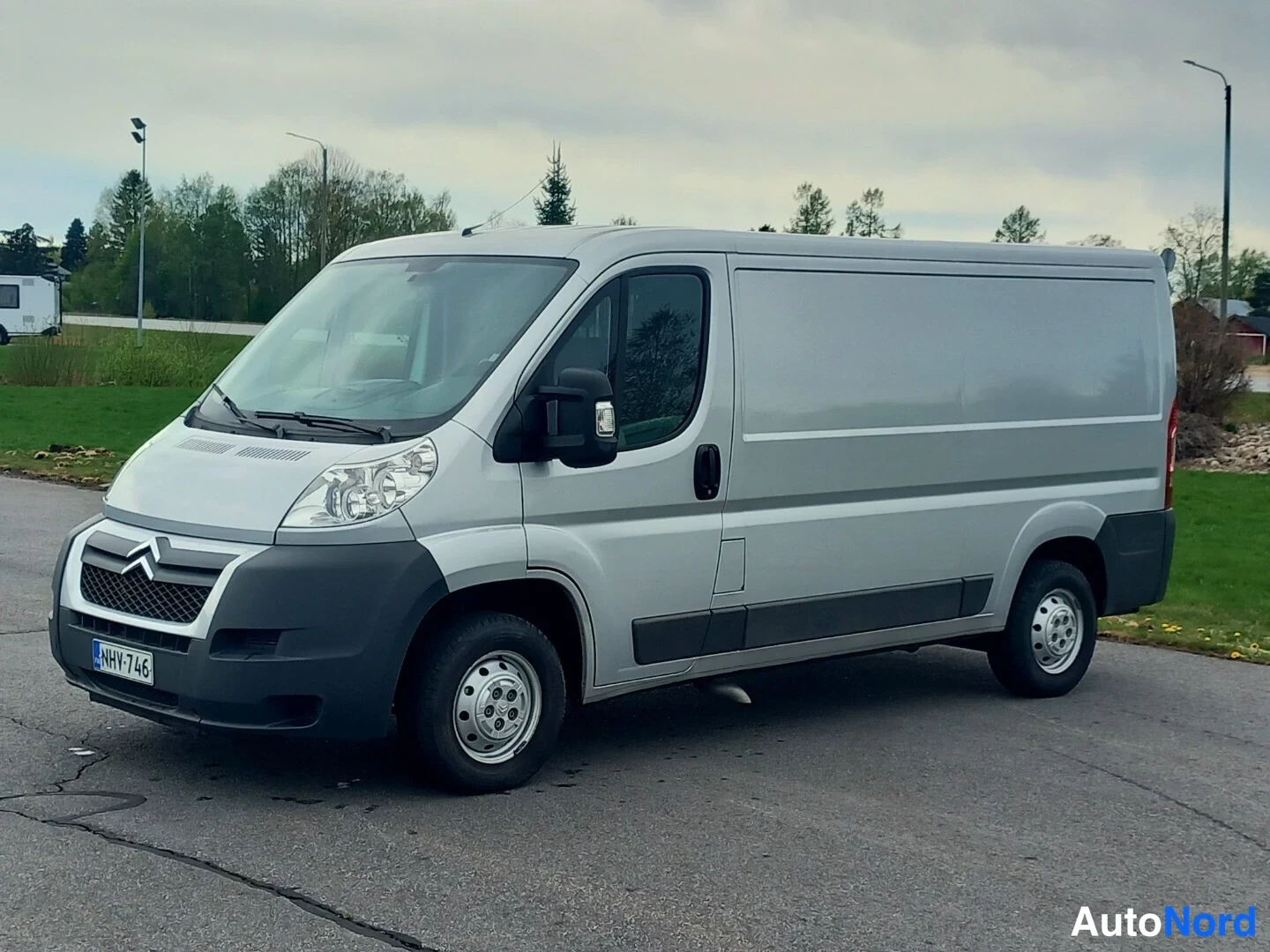 Etuviisto, nokka vasemmalle: Hopeanharmaa Citroen-pakettiauto kolmesta neljänneksestä edestä vasemmalle kuvattuna parkkipaikalla.