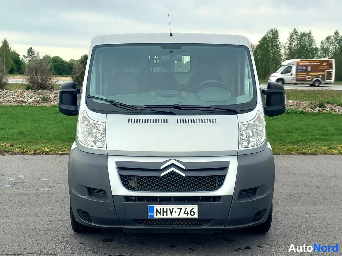 Edestä: Hopeanharmaan Citroën-pakettiauton etunäkymä, rekisterikilpi.