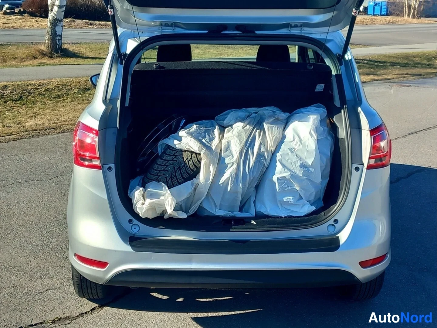 Takaa: Auto takaa avattuine tavaratiloineen, takaluukussa ja puskurissa näkyvät takavalot.