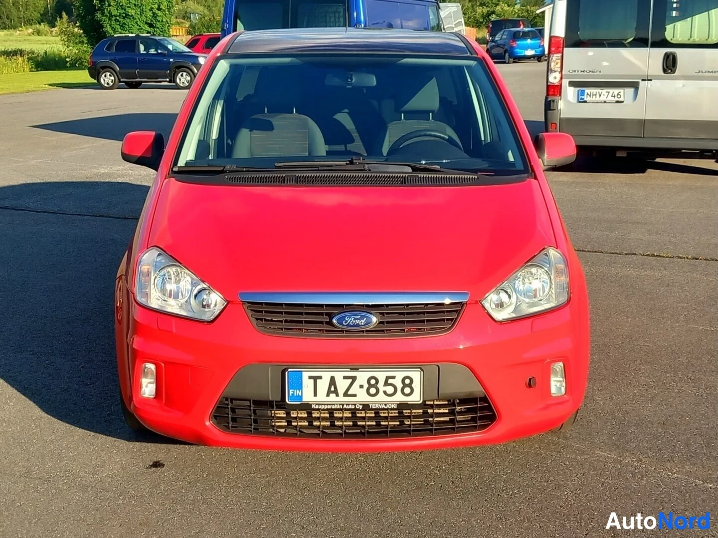 Edestä: Punaisen henkilöauton etupää suoraan edestä, Ford-merkki grillissä, rekisterikilpi FIN.