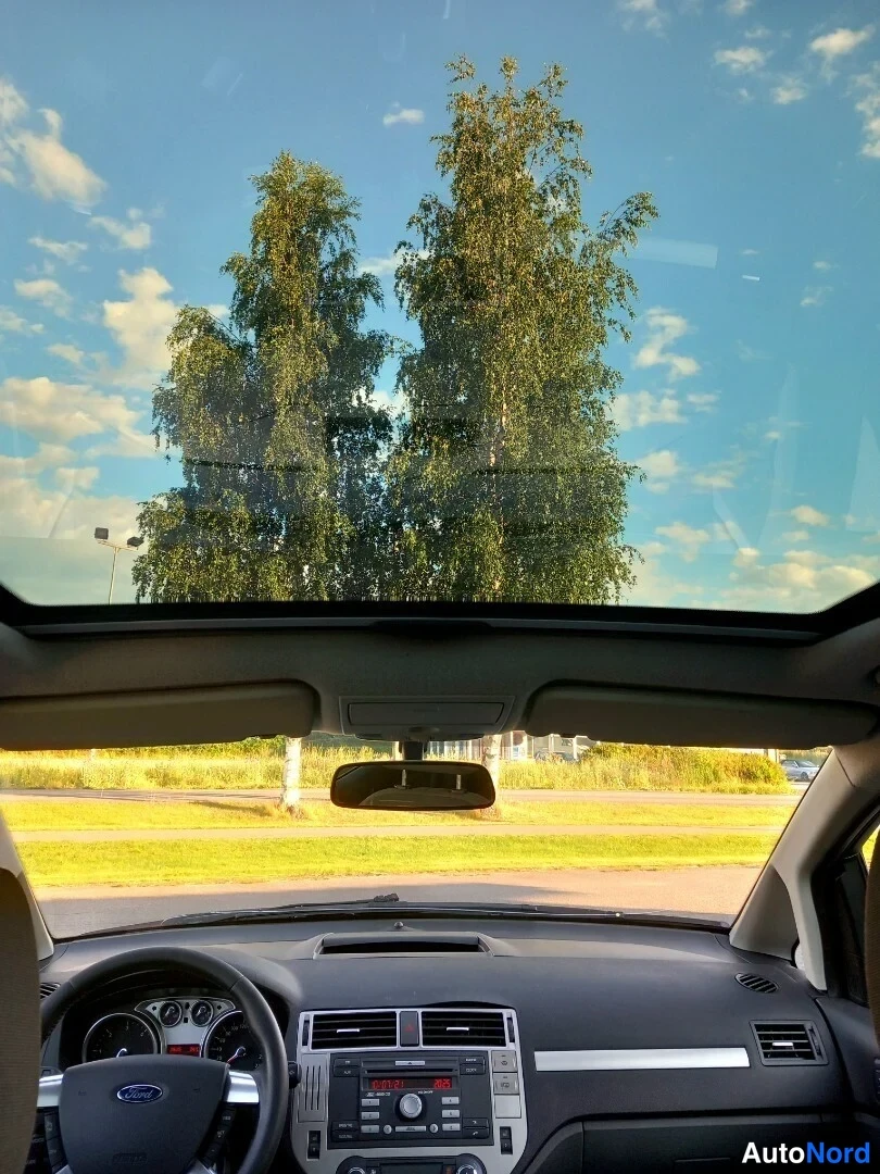 Muu: Näkymä auton sisältä kohti panoraamikattoa ja tuulilasin taakse avautuvaa maisemaa.