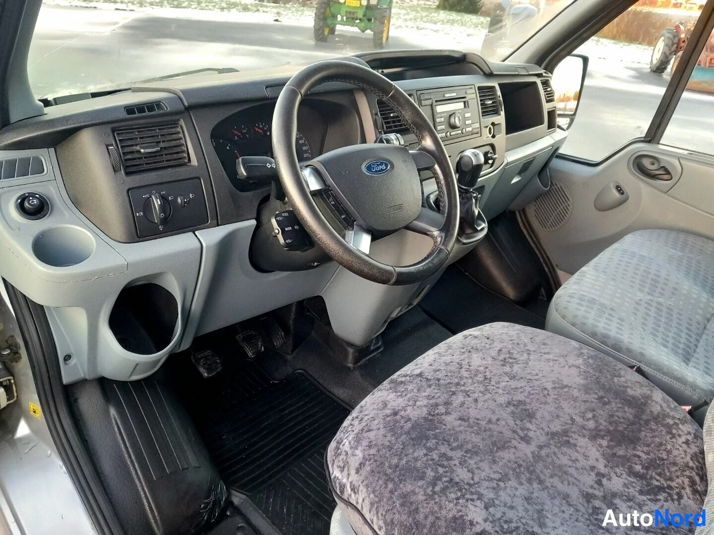Edestä: Kuljettajan puolen cockpit: ohjauspyörä Ford-logolla, manuaalivaihto- ja käsijarruvipu, radio ja mittaristo.