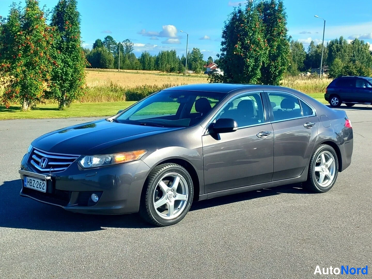 Etuviisto, nokka vasemmalle: Honda Accord -sedan tummanharmaana edestä vasemmalta kuvattuna, rekisteri.