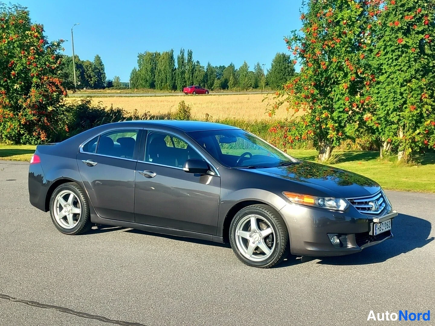 Etuviisto, nokka oikealle: Honda Accord -sedan tummanharmaana etukohtaa oikealta kuvattuna, rekisteri.