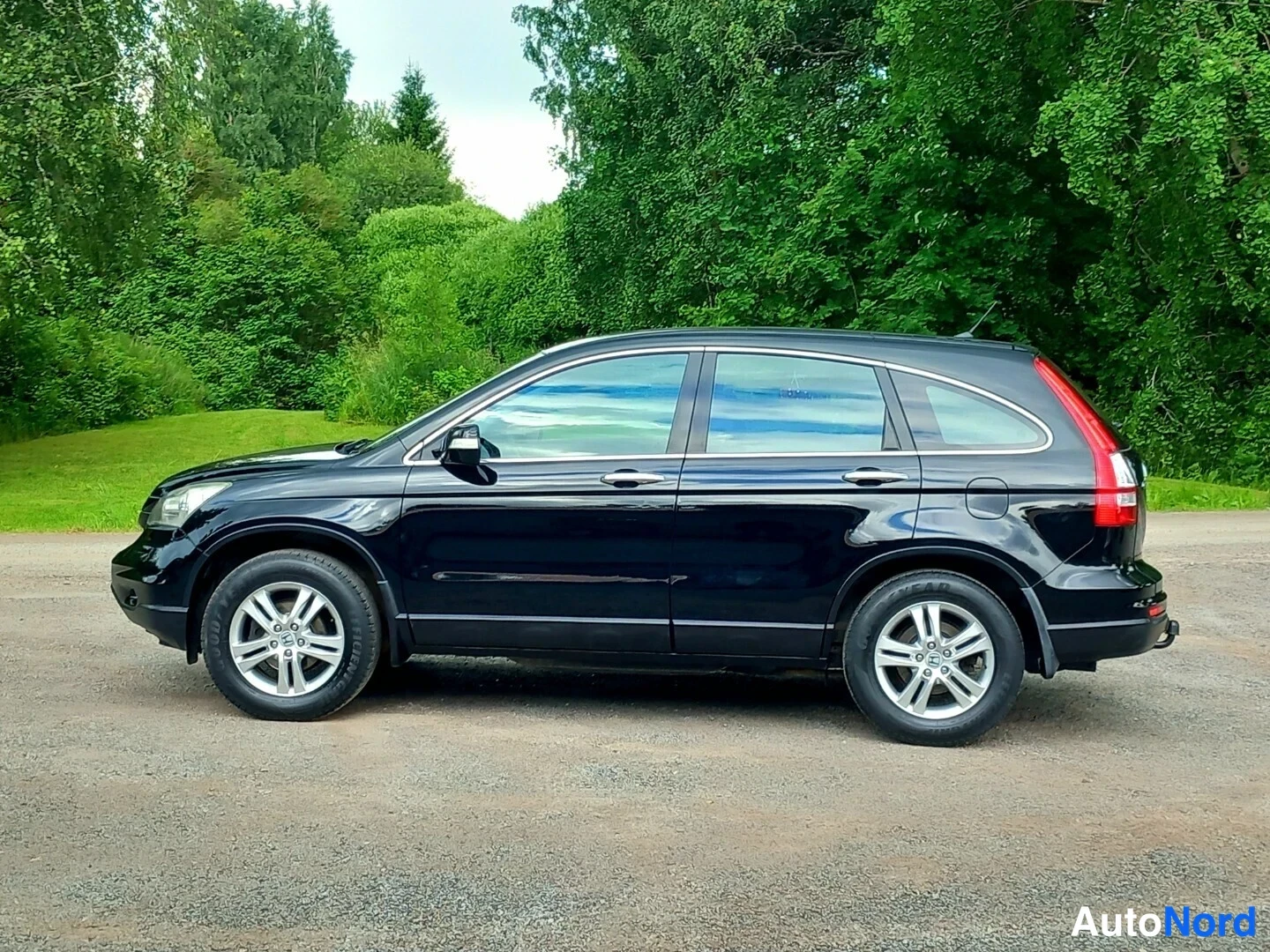 Sivulta: Mustan Honda CR-V:n sivukuva vasemmalta puolelta, hinauskoukun napa näkyvissä takana.
