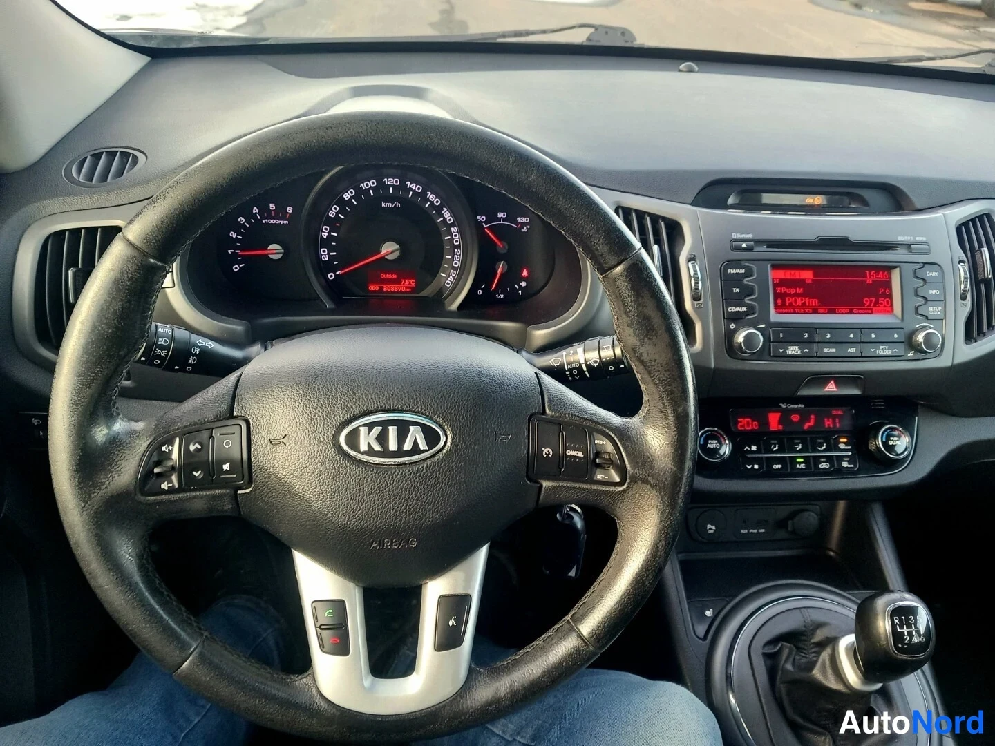 Muu: Ohjaamo näkyvissä: KIA-merkkinen monitoimiohjauspyörä, mittaristo ja keskikonsoli radiolla, manuaalivaihteen keilalla ja ESP-AUTO-napilla.