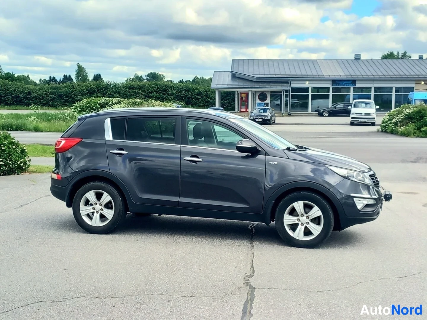 Sivulta: Kia Sportage tummanharmaa, kolmivartaloinen etunäkymä oikealta
