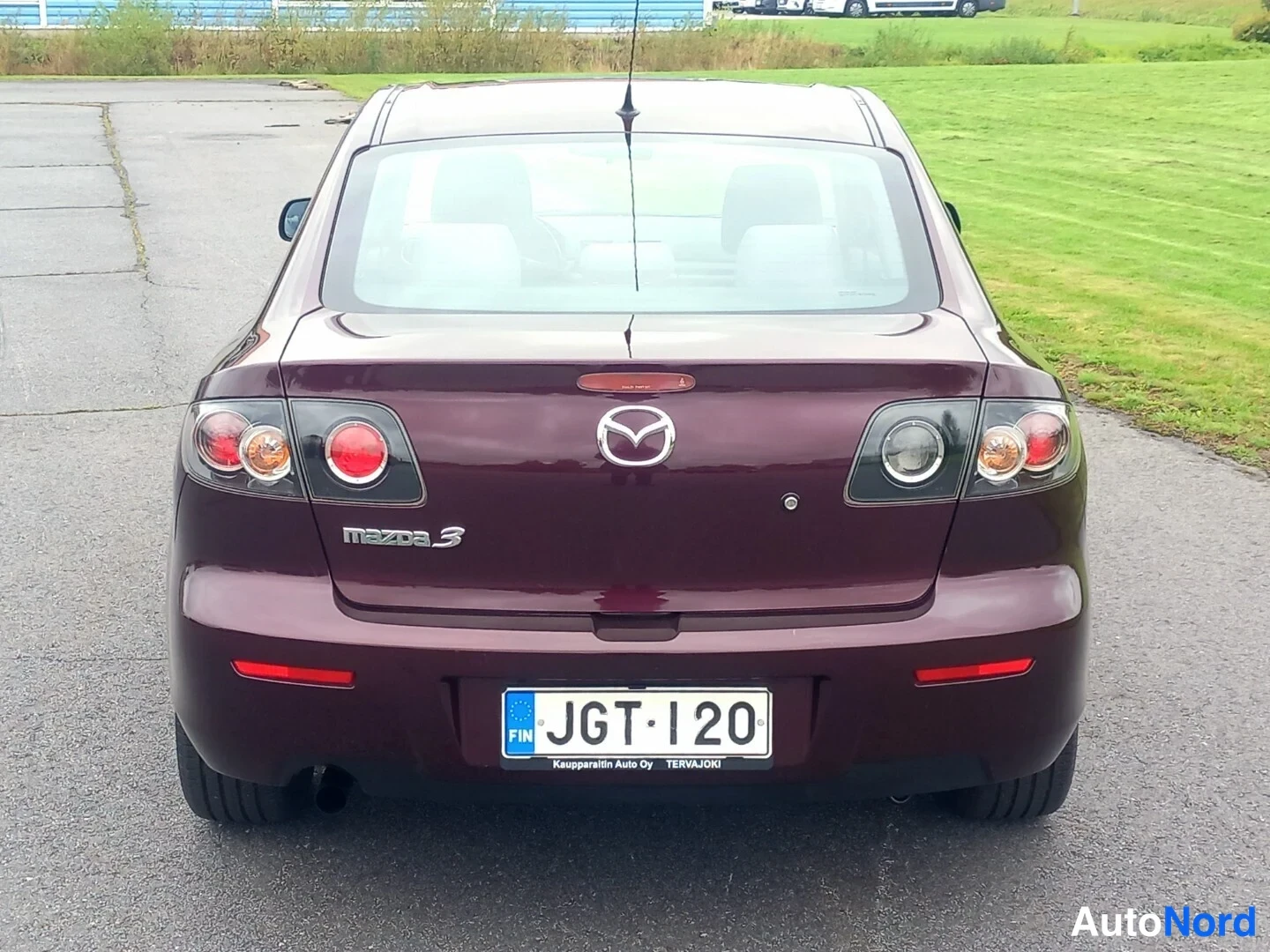 Takaa: Mazda 3:n takaosa suoraan takaa, tummanpunainen maalaus, rekisterikilpi, mallimerkinta Mazda 3 takaluukussa.