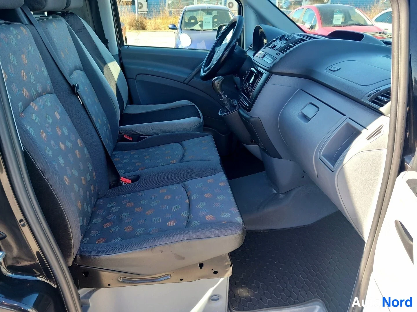 Muu: Mercedes-Benz Vito -henkilöauton takaistuimelle kuvattu sisätilanäkymä: kaksipaikkainen penkki kankaanverhoilulla, etupenkit ja kojelauta.