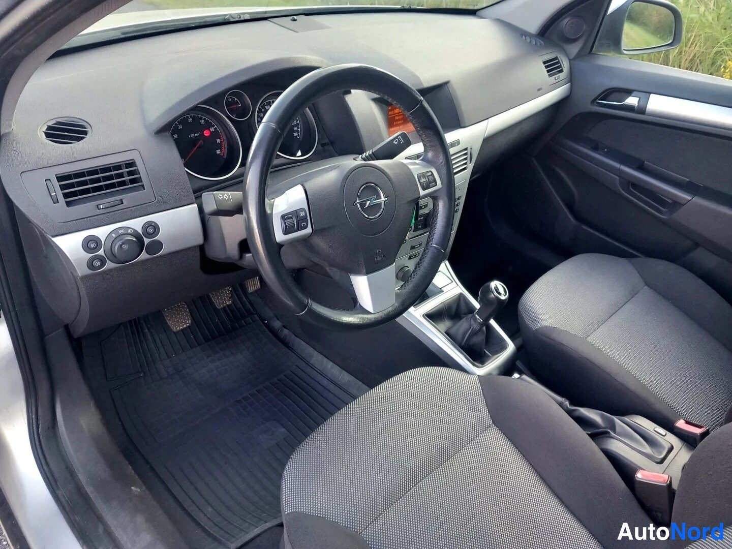 Muu: Opel Astra -ohjaamon sisäkuva, paini on näkyvissä ja kuljettajan istuin vasemmalla