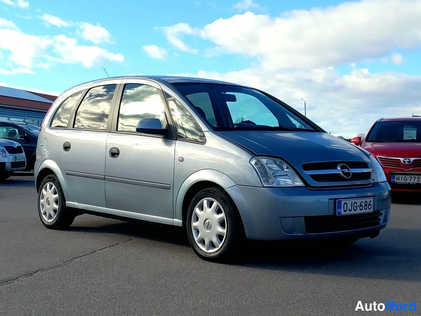 Etuviisto, nokka oikealle: Opel Meriva -auton etukulmakuva, etupaneeli ja oikea kylki näkyvissä, hopeinen koriväri.