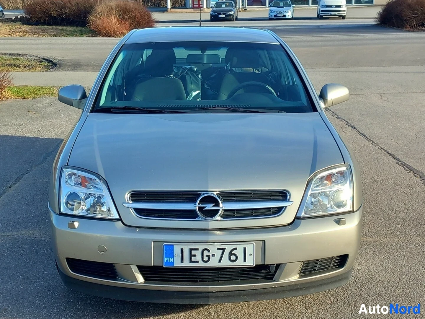 Edestä: Beige Opel Vectran etunäkymä, rekisterikilpi, sisätiloissa peitospaperit.