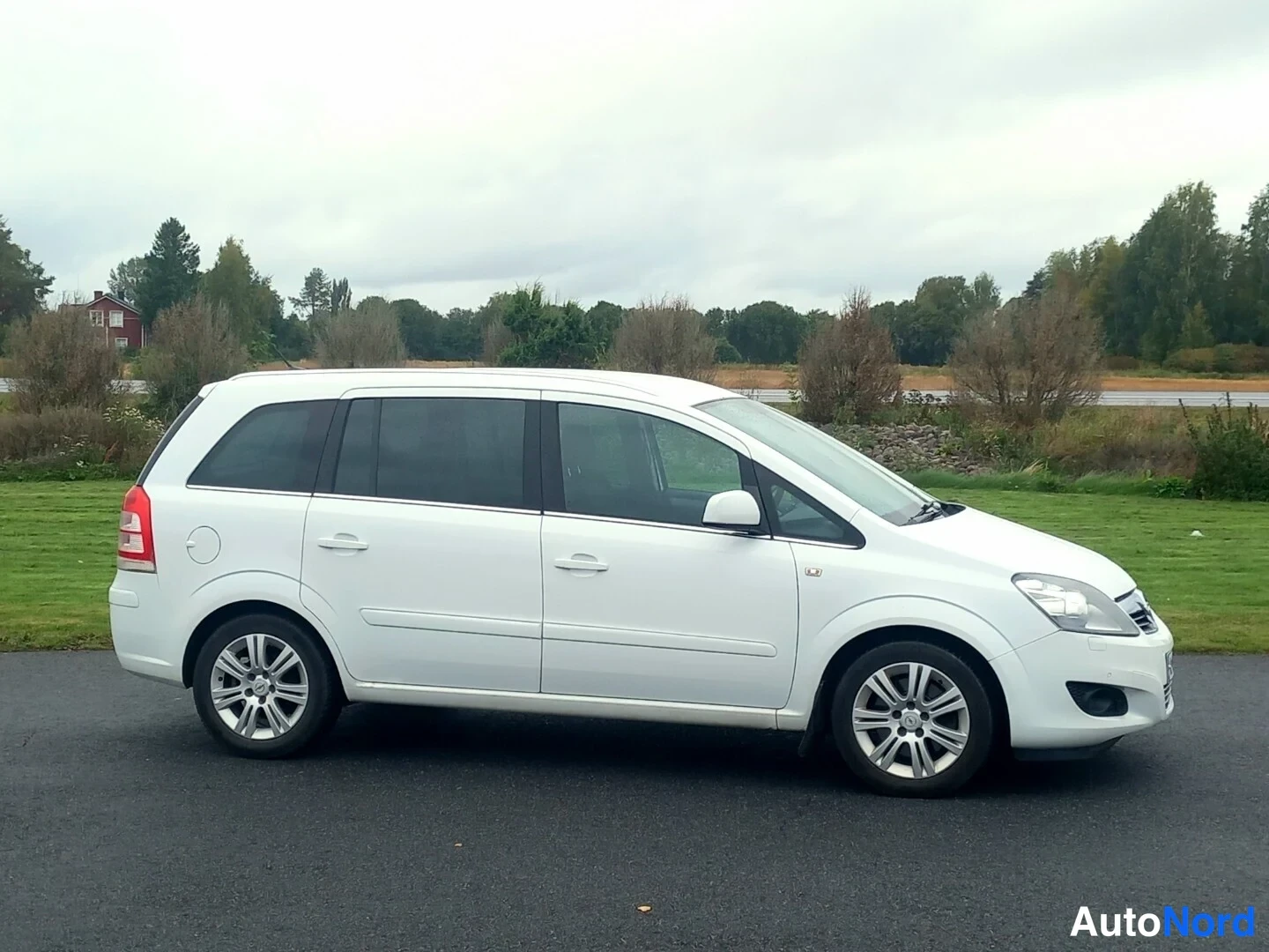 Etuviisto, nokka oikealle: Valkoinen Opel Zafira -henkilöauto sivulta etuosasta kuvattuna, keulakorki osoittaa oikealle.