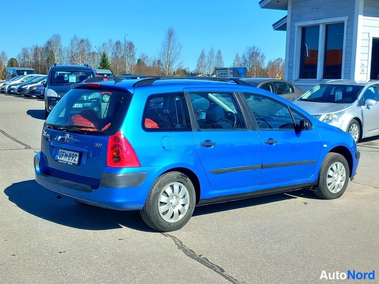 Takaviisto: Sininen Peugeot 307 farmari takaa oikealta, rekisteritunnus.