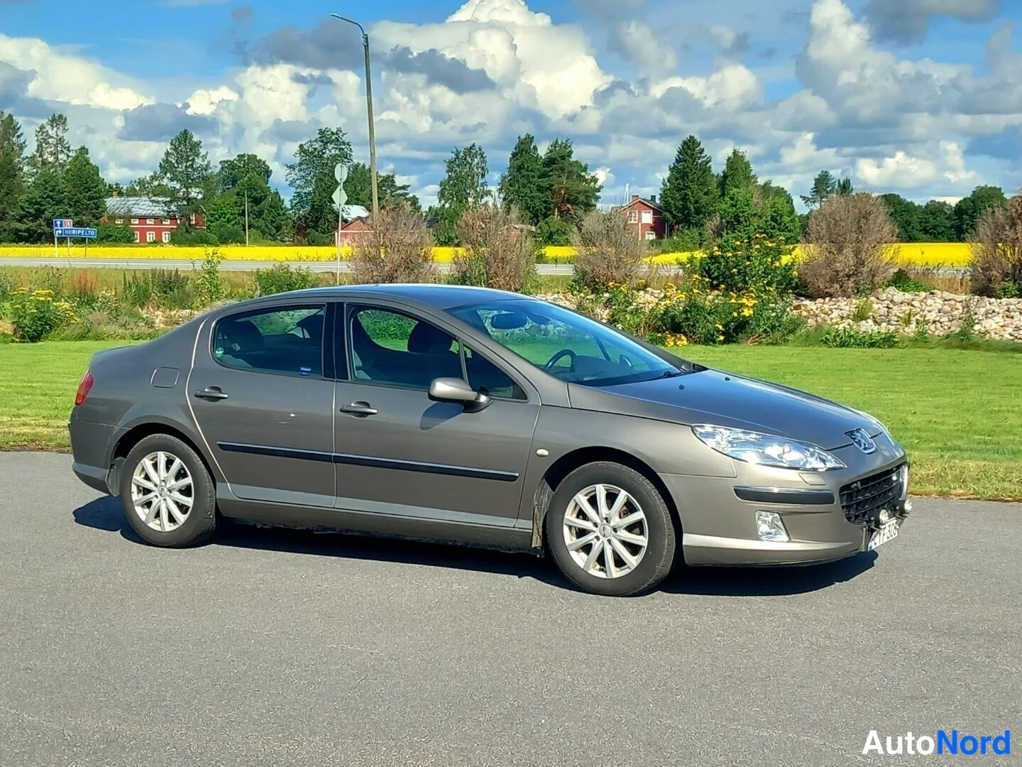 Etuviisto, nokka oikealle: Peugeot 407 -sedan kolmelinjainen etukulman kuva vasemmalta, auto harmaanruskea, valumetallivanteet
