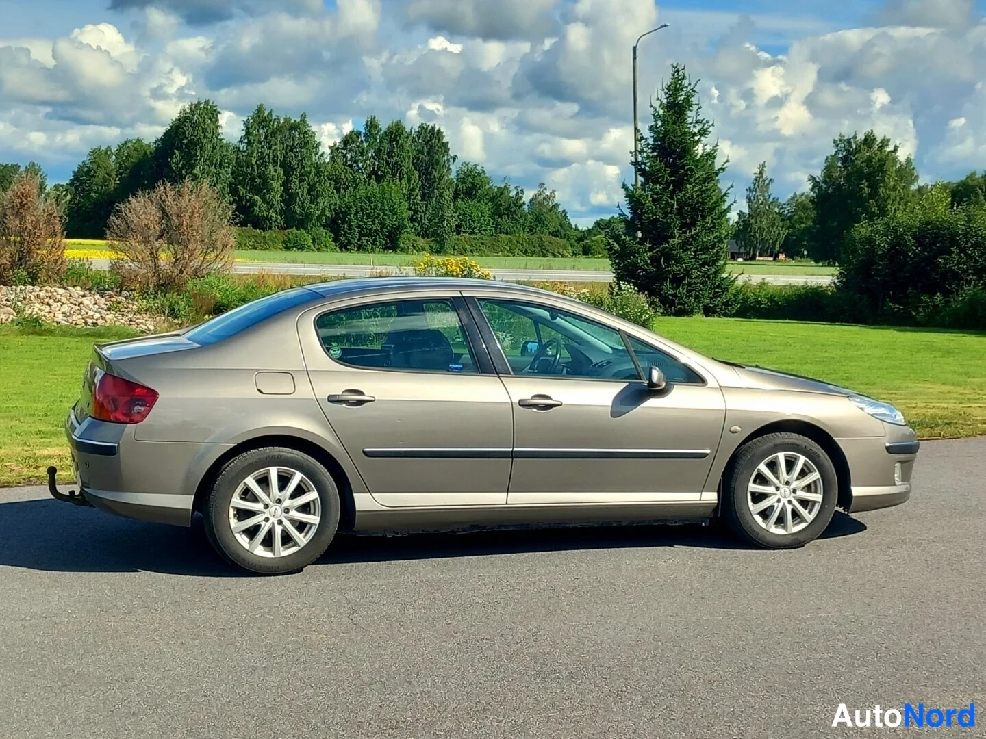 Takaviisto: Peugeot 407 -sedanin takakolmannes keula oikealla, auton perä ja oikea kylki näkyvissä.
