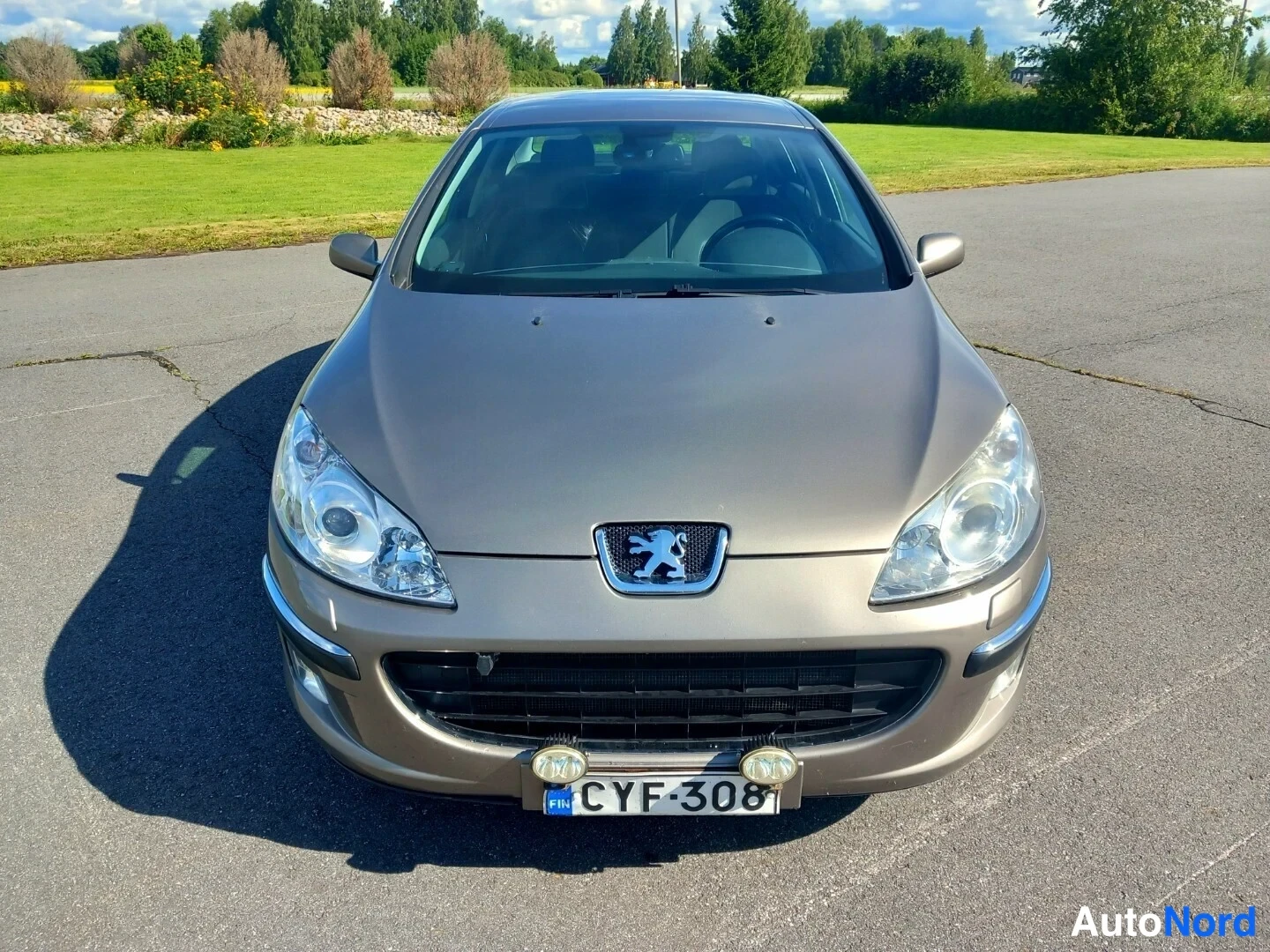Edestä: Peugeot 407 -henkilöauto edestä kuvattuna, etusäleikkö ja lyhdyt näkyvissä, rekisteritunnus.