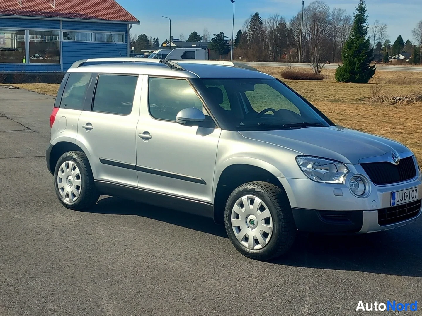 Etuviisto, nokka oikealle: Hopeanvärinen Skoda Yeti -auto kolmanneltasektorilta nokka oikealle, rekisterikilpi näkyvissä.