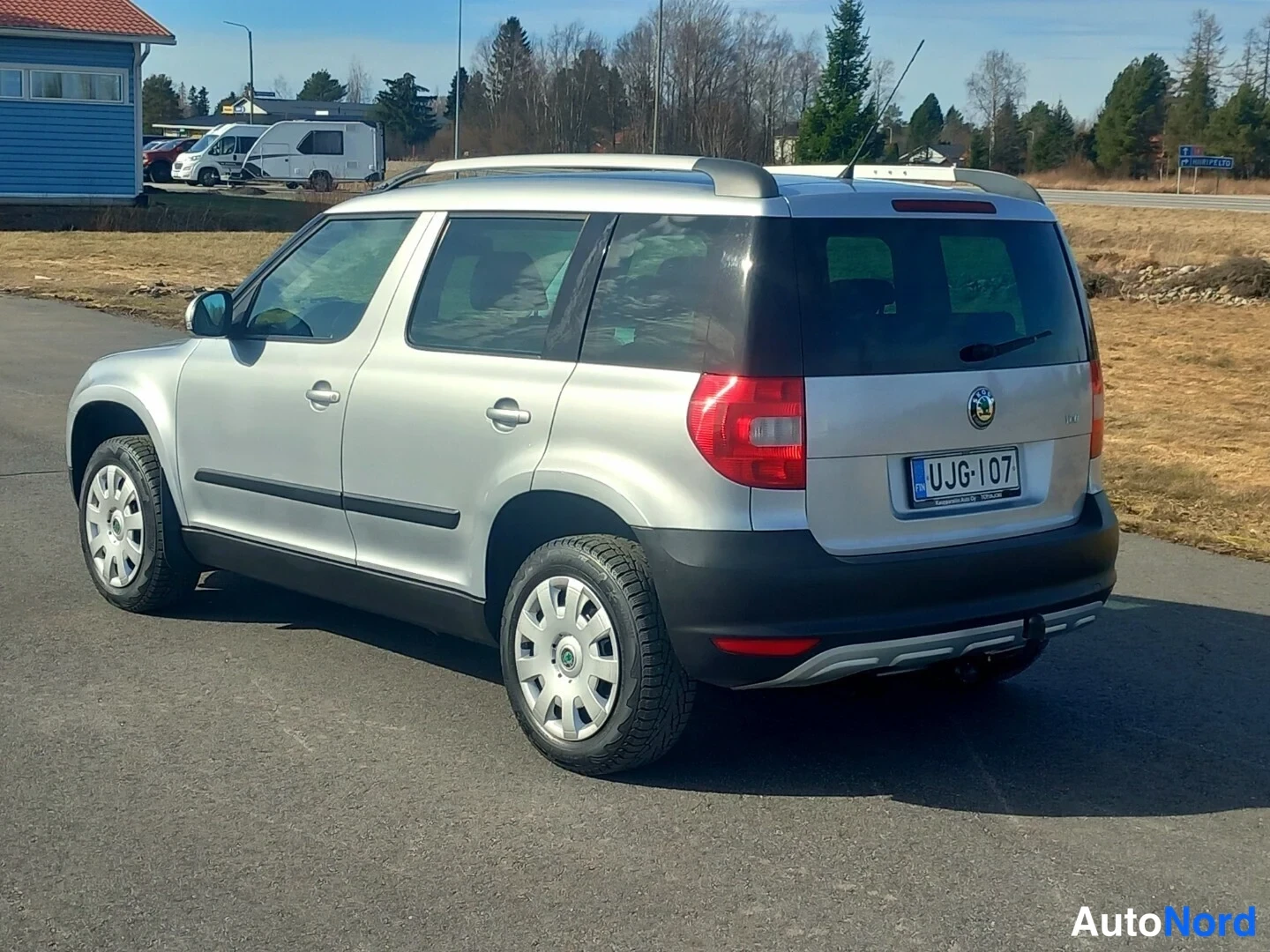 Takaviisto: Silver Skoda Yeti rear three-quarter view showing tail lights, boot lid with badge and 'YETI' script, license plate, black rear bumper trim, towing receiver stu