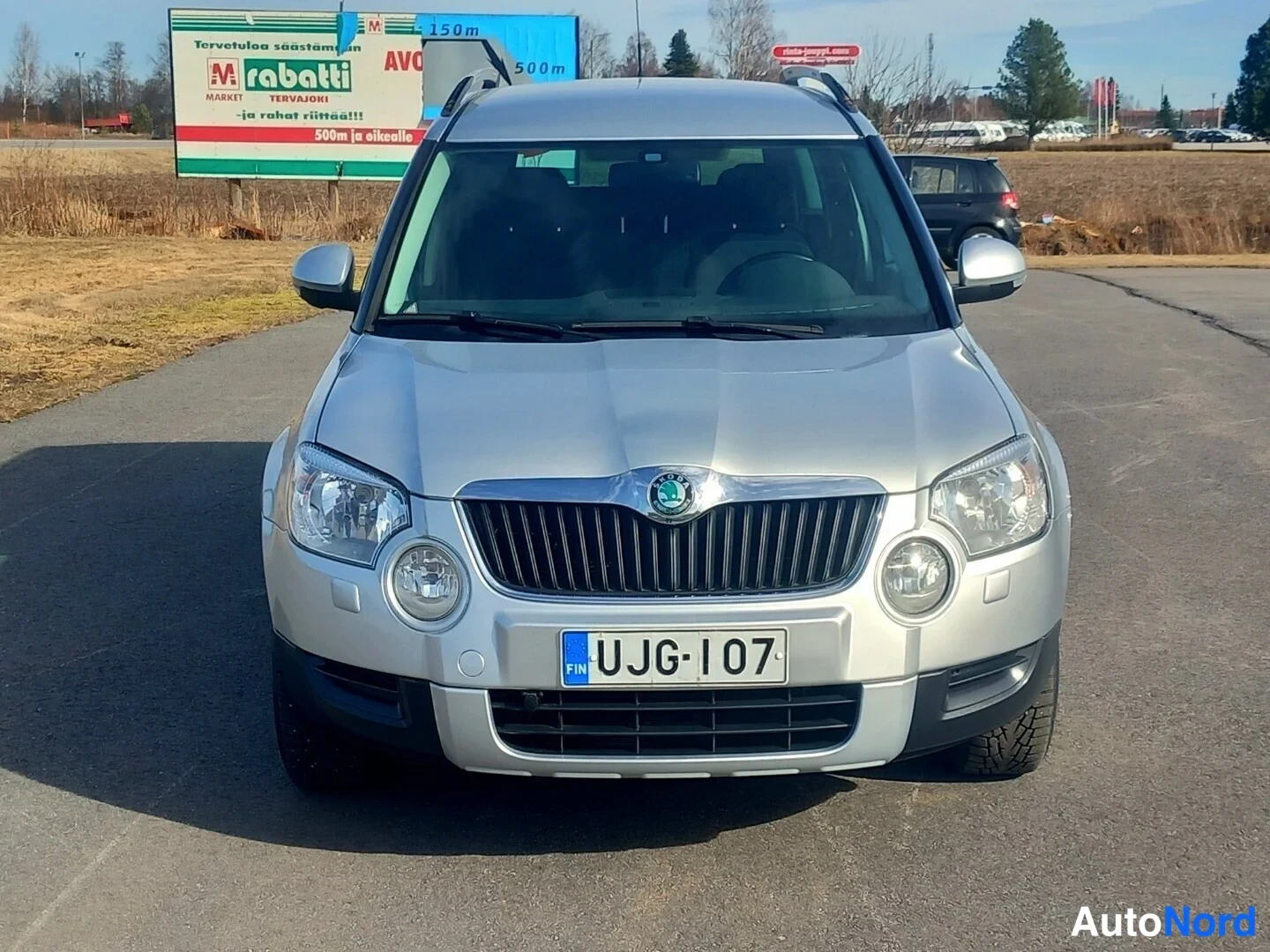 Edestä: Hopeanvärinen Skoda Yeti suoraan edestä kuvattuna; rekisteritunnus luettavissa etupuskurissa.