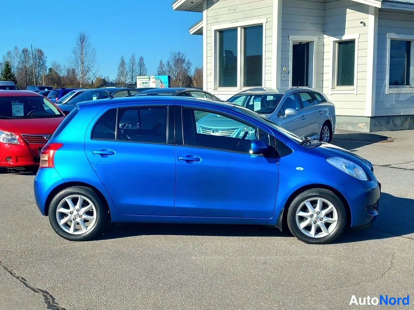Etuviisto, nokka oikealle: Sininen Toyota Yaris -viistosti edestä oikealta kuvattuna